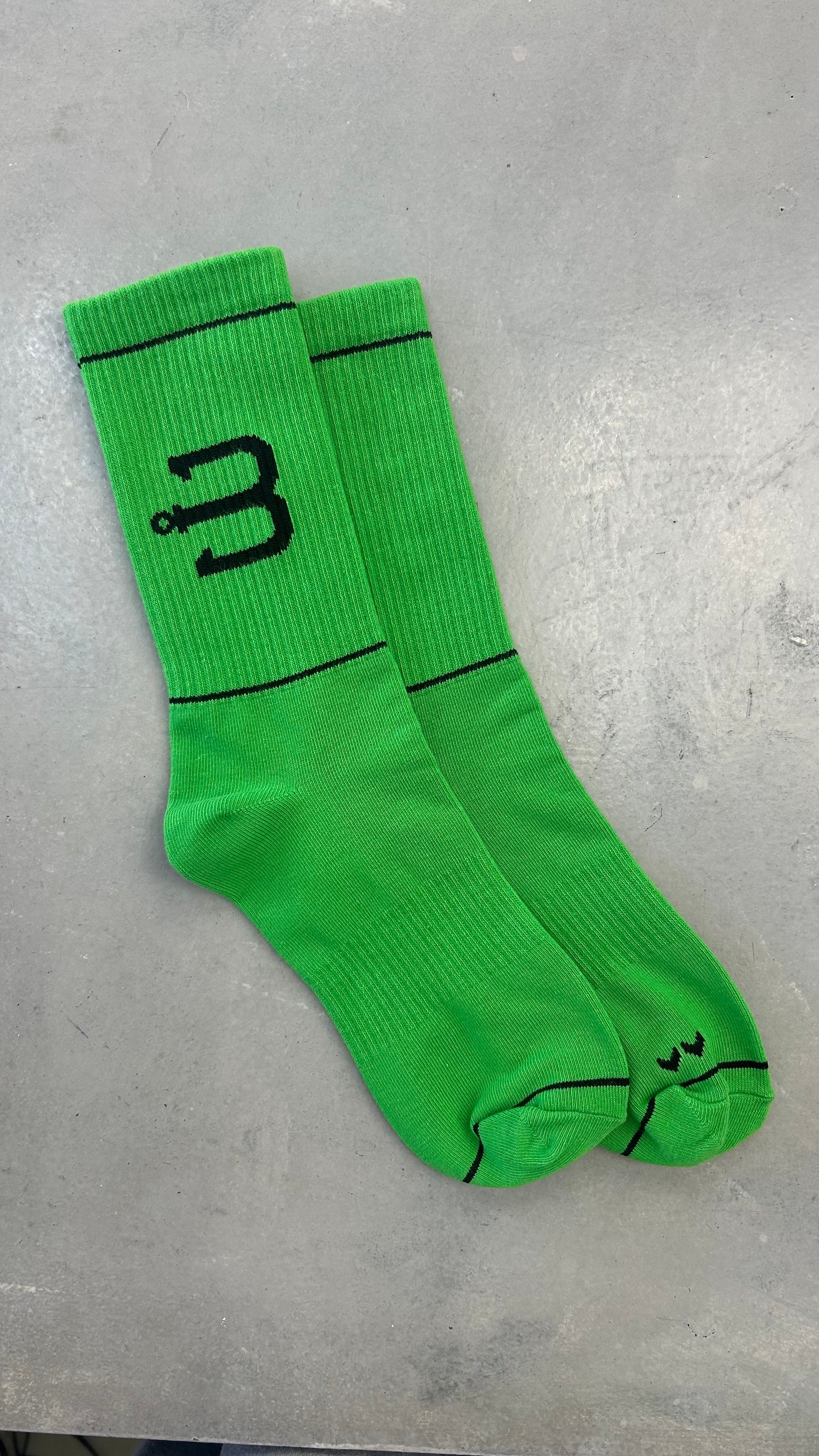 A pair of bright green sport socks with BAHNS logo