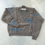 A greyish brown wool sweater with blue knit pattern