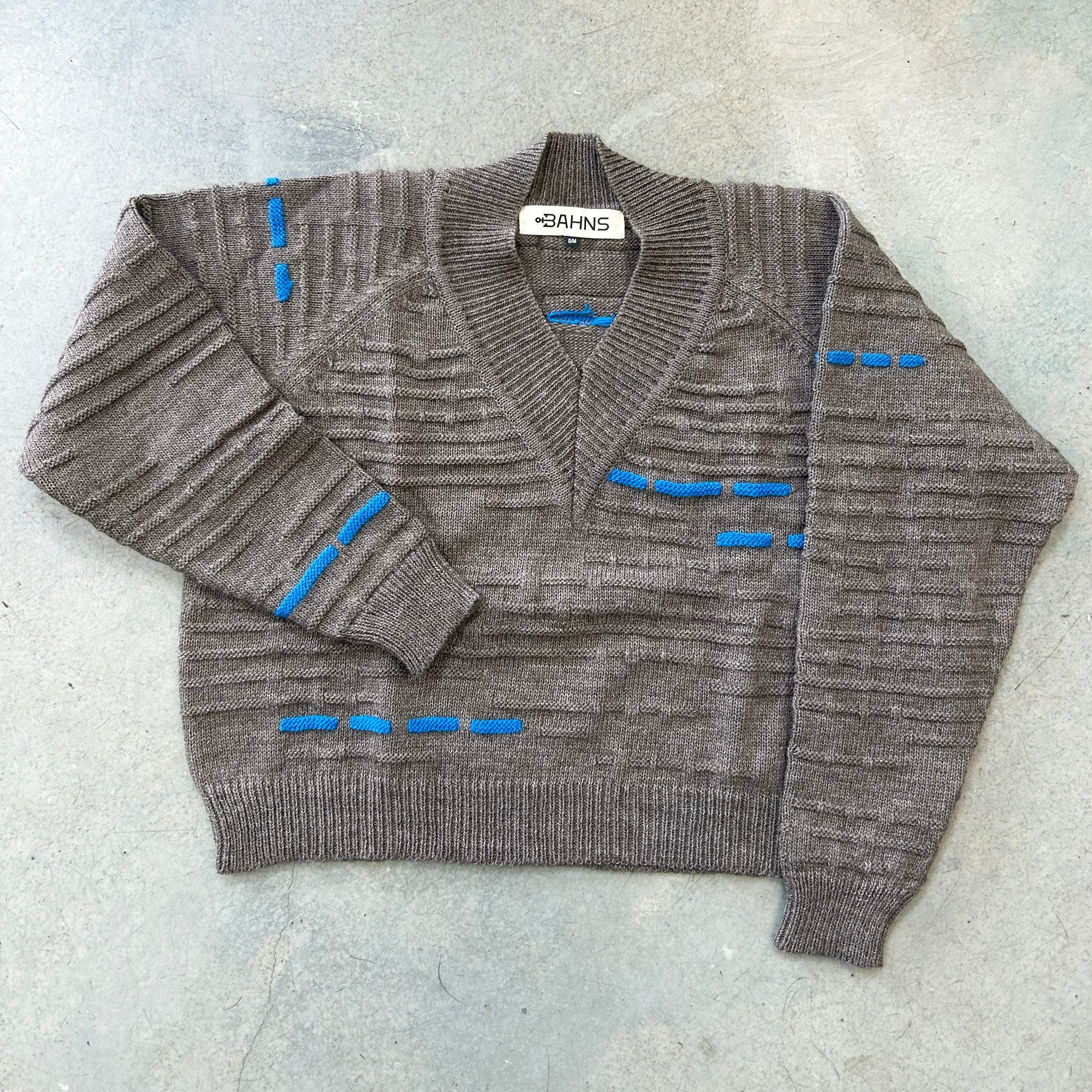 A greyish brown wool sweater with blue knit pattern