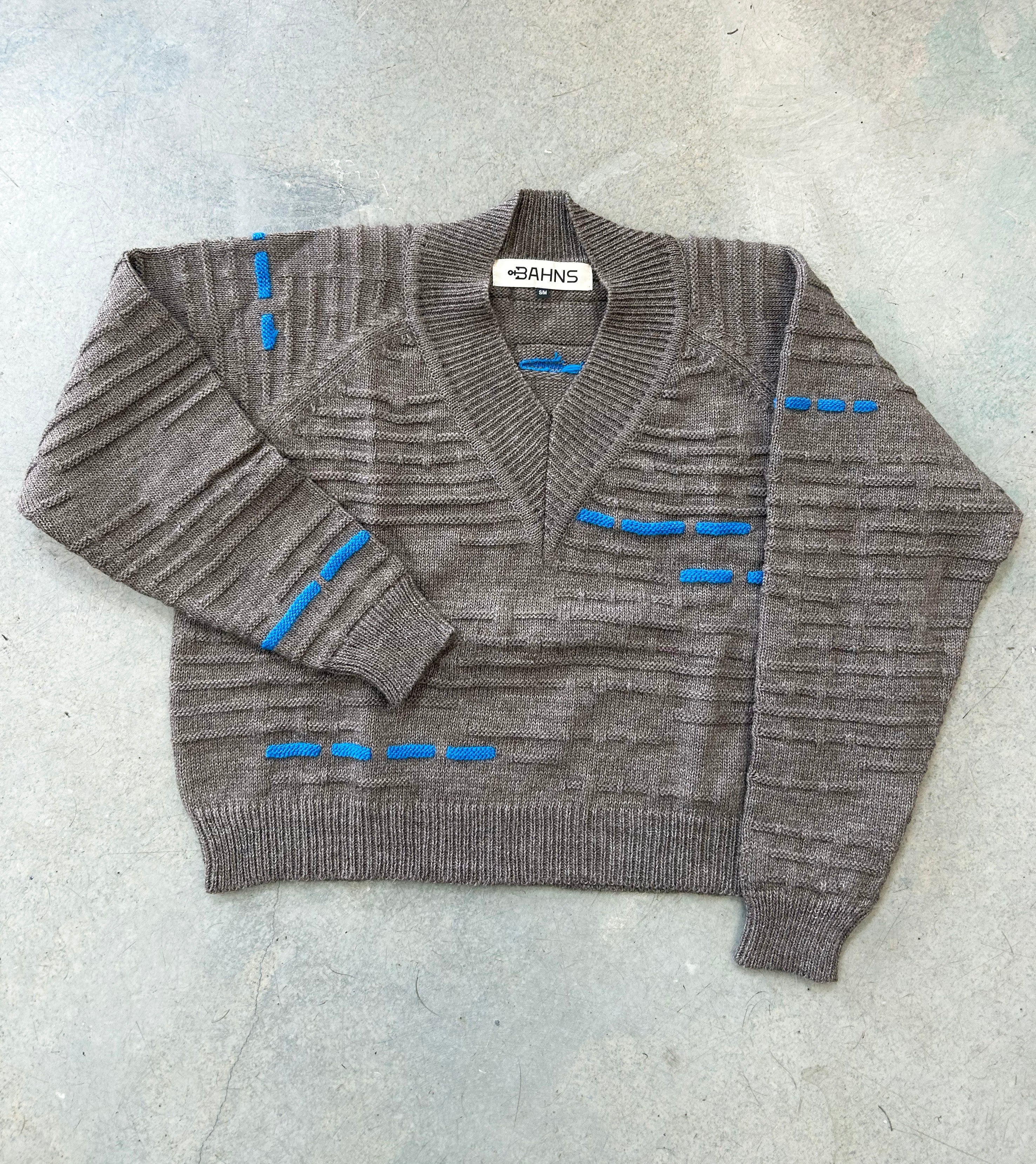 A greyish brown wool sweater with blue knit pattern