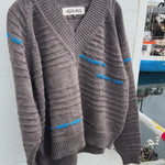 Brown wool sweater with blue knit details swaying in the wind